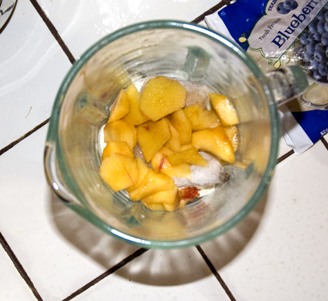 Sliced peaches added to a smoothie