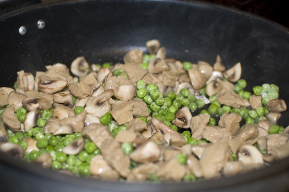mushrooms, seitan and peas mixed in pan